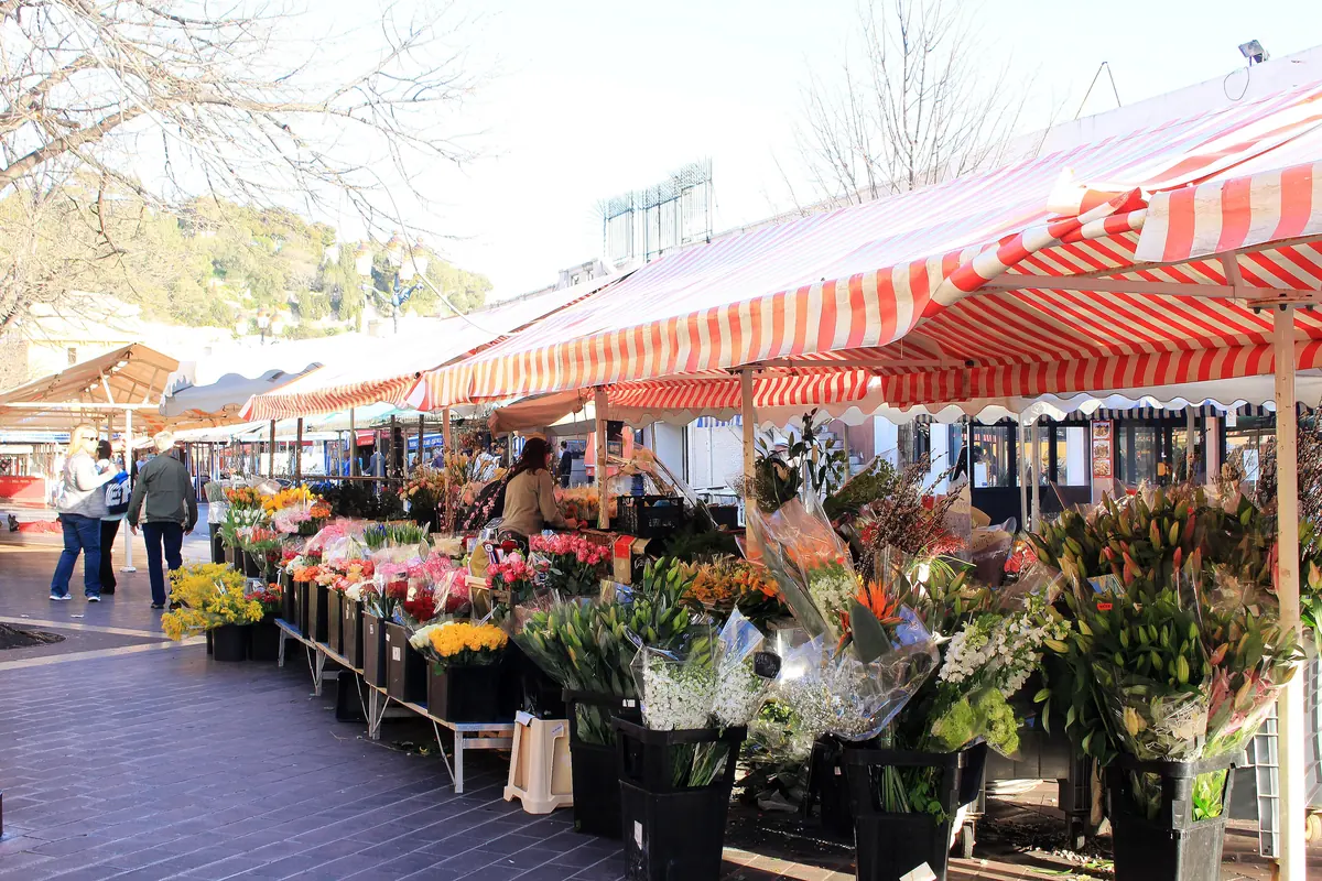 Le marché aux fleurs du cours Saleya à Nice le matin, ses étals de bouquets sous les toiles rayées.