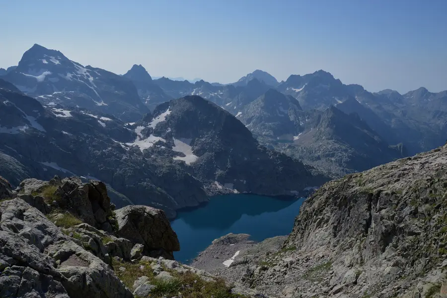 Un lac de montagne bleu au creux des sommets rocheux du parc national du Mercantour.